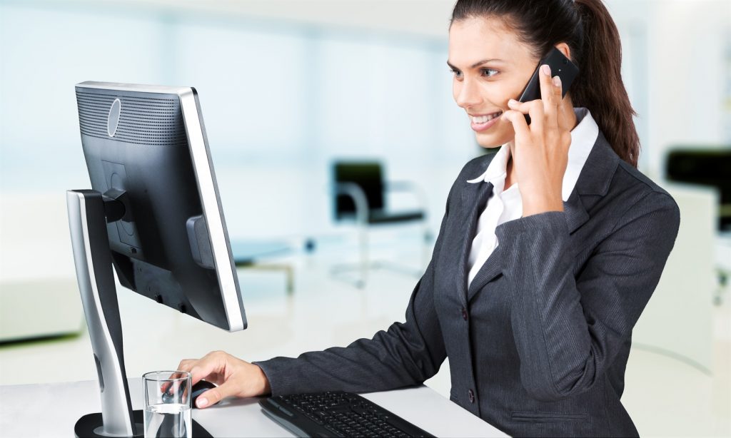 Mujer sentada frente a su laptop contestando una llamada